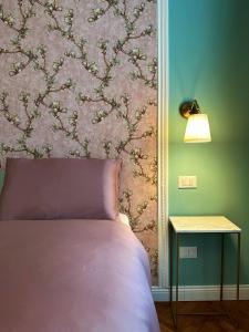 ein Schlafzimmer mit einem Bett und einer Wand mit einem Blumenbild in der Unterkunft A casa di Bruna in Gorizia