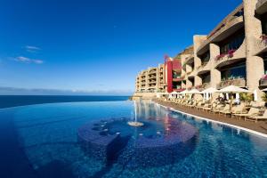 a swimming pool with a fountain in the middle of a building at Gloria Palace Royal Hotel & Spa in Puerto Rico de Gran Canaria