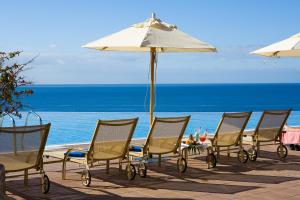 a group of chairs and an umbrella on the beach at Gloria Palace Royal Hotel & Spa in Puerto Rico de Gran Canaria