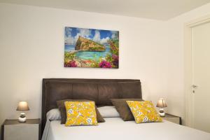 a bedroom with a bed and a painting on the wall at Variopinto Home in Ischia Town