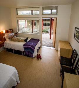 a man is sitting on a bed in a bedroom at Naramata Centre in Naramata