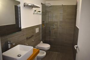 a bathroom with a toilet and a sink and a shower at Variopinto Home in Ischia Town +25 photos