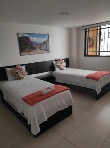 1 dormitorio con 2 camas y ventana en Aptahotel Guest House en San Gil