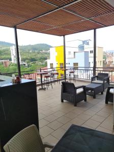 uma varanda com cadeiras e mesas num edifício em Aptahotel Guest House em San Gil