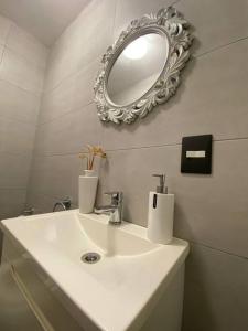 y baño con lavabo blanco y espejo. en Precioso departamento 2 ambientes Julian A. y Castillo en Buenos Aires