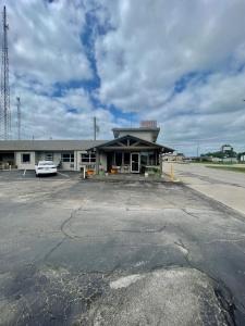 a building with a car parked in a parking lot at Economy Inn in Ada