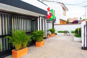 a restaurant with potted plants in front of a building at Hotel BogoSuba 127 in Bogotá