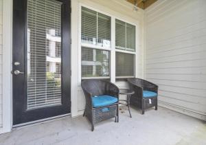 a porch with two chairs and a table and windows at Luxurious 1 Bedroom Apartment Near Braves Stadium in Atlanta