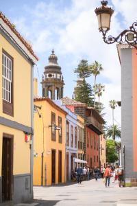 une rue de la ville avec une tour d'horloge en arrière-plan dans l'établissement Marhaba La Laguna, alojamiento en centro histórico de San Cristóbal de La Laguna, à La Laguna