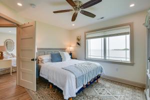 a bedroom with a bed and a ceiling fan at Waterfront Maryland Vacation Home Private Beach! in Ridge