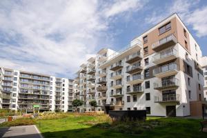 a large white apartment building with a grass yard at Cozy apartment Kazimierza 48, Wola in Warsaw