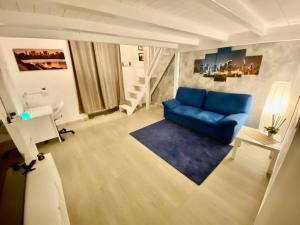 un soggiorno con divano blu e scala di la Piccola Dimora appartamento a Taranto
