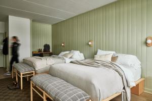 3 camas en una habitación con paredes verdes en Bluebird Lake Placid, en Lake Placid