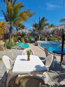 a white table and chairs next to a swimming pool at Bora Bora Bungalows in Los Órganos