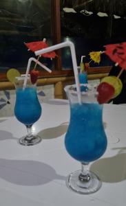 two blue cocktails with straws on a table at Bora Bora Bungalows in Los Órganos