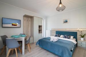 a bedroom with a bed and a table and a desk at Róża Bałtyku - Apartamenty i Pokoje A in Dębki