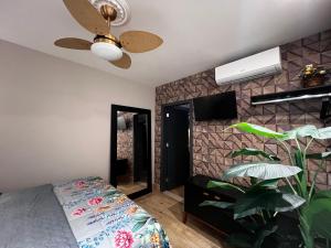 een slaapkamer met een bed en een plafondventilator bij Hotel APART Zuccolotto 2 in Aracruz