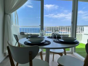 a dining room with a table with a view of the ocean at Axenic Retreat - Panoramic Ocean View, Private Terrace, Sleeps 4, Ensuite Bathroom, New Redesign in Sesimbra +31 photos