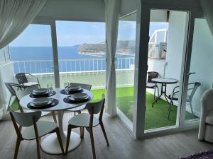 a table and chairs in a room with a view of the ocean at Axenic Retreat - Panoramic Ocean View, Private Terrace, Sleeps 4, Ensuite Bathroom, New Redesign in Sesimbra