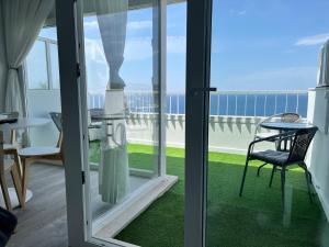 a view of a balcony with a table and a chair at Axenic Retreat - Panoramic Ocean View, Private Terrace, Sleeps 4, Ensuite Bathroom, New Redesign in Sesimbra