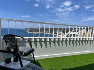 a balcony with a chair and a view of the ocean at Axenic Retreat - Panoramic Ocean View, Private Terrace, Sleeps 4, Ensuite Bathroom, New Redesign in Sesimbra