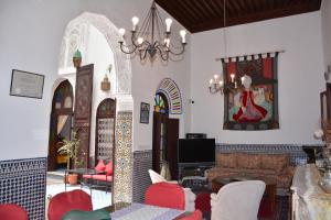 ein Wohnzimmer mit roten und weißen Möbeln und einem Kronleuchter in der Unterkunft Dar Al Batoul in Fès