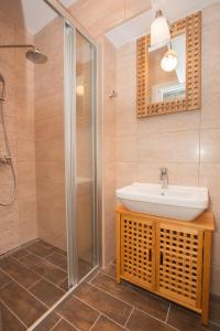 ein Bad mit einem Waschbecken und einer Dusche in der Unterkunft Apartments Orica I in Suđurađ