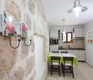 eine Küche und ein Esszimmer mit einer Steinmauer in der Unterkunft Apartments Orica I in Suđurađ