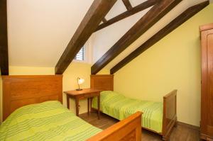 a attic bedroom with two beds and a table at Apartments Orica II in Šipanska Luka