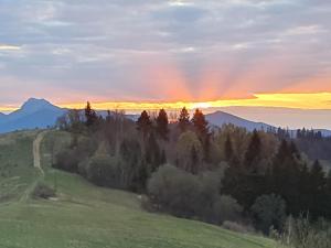 a sunset over the mountains with a rainbow in the sky at Drevenice Osádka in Osádka