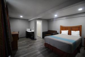 een hotelkamer met een bed en een stoel bij Starlite Motel in San Bernardino
