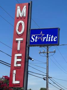 een bord voor een Santa Cruz motel en een bord voor een autodealer bij Starlite Motel in San Bernardino