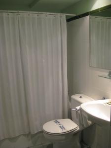 a bathroom with a white shower curtain and a toilet at Hotel Rural Loizu in Burguete +27 photos