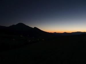 a sunset over a mountain range with the sun setting at Drevenice Osádka 
