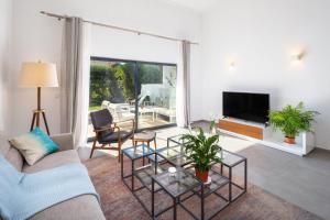 ein Wohnzimmer mit einem Sofa und einem TV in der Unterkunft Casa Relax à Olhos Albufeira in Albufeira