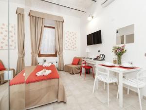 een kamer met een bed en een tafel en stoelen bij Coral flat Colosseo in Rome