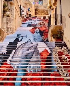 un escalier avec une peinture sur son côté dans l'établissement NotoDream, à Noto