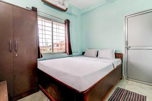 Cama en habitación con ventana grande en Flagship Hotel Ashish Kiran, en Dhanbād