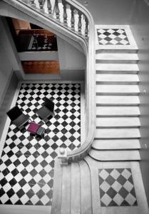a stairway with a checkered floor with two chairs and a stair case at Onix Liceo in Barcelona