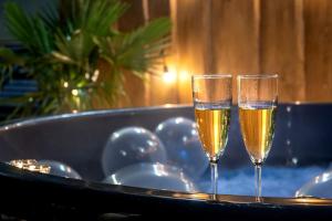 two glasses of champagne on a tray in front of a tub at Domek nad Morzem Łeba Ruska Bania Sauna Jacuzzi in Łeba