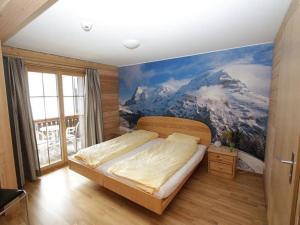 a bedroom with a mountain mural on the wall at Hotel Restaurant Sonnenberg in Mürren