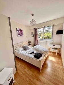 a bedroom with a bed and a desk and a window at Appartement sur le port. in Grandcamp-Maisy