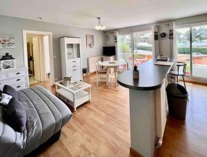 a living room with a couch and a table at Appartement sur le port. in Grandcamp-Maisy