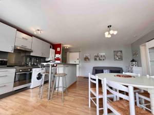 a kitchen and living room with a table and chairs at Appartement sur le port. in Grandcamp-Maisy