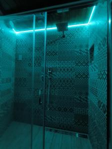 a bathroom with a glass shower with a blue light at B&B Vicolo50 Salerno in Salerno