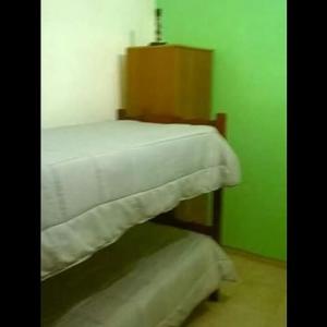 a room with a bed with a green wall at Departamentos del Puerto Verde in Paraná