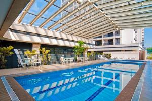 una piscina con techo de cristal y un edificio en Linda suite em hotel aeroporto de Congonhas, en São Paulo