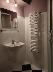 a bathroom with a sink and a shower with a mirror at Hajstra in Krempna
