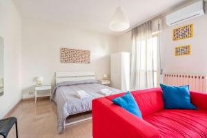 a living room with a red couch and a bed at Casa Vacanze Visit Puglia in Casamassima