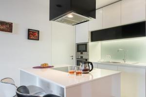 a white kitchen with two glasses on a counter at Apartamento Qian Caves de Gaia in Vila Nova de Gaia